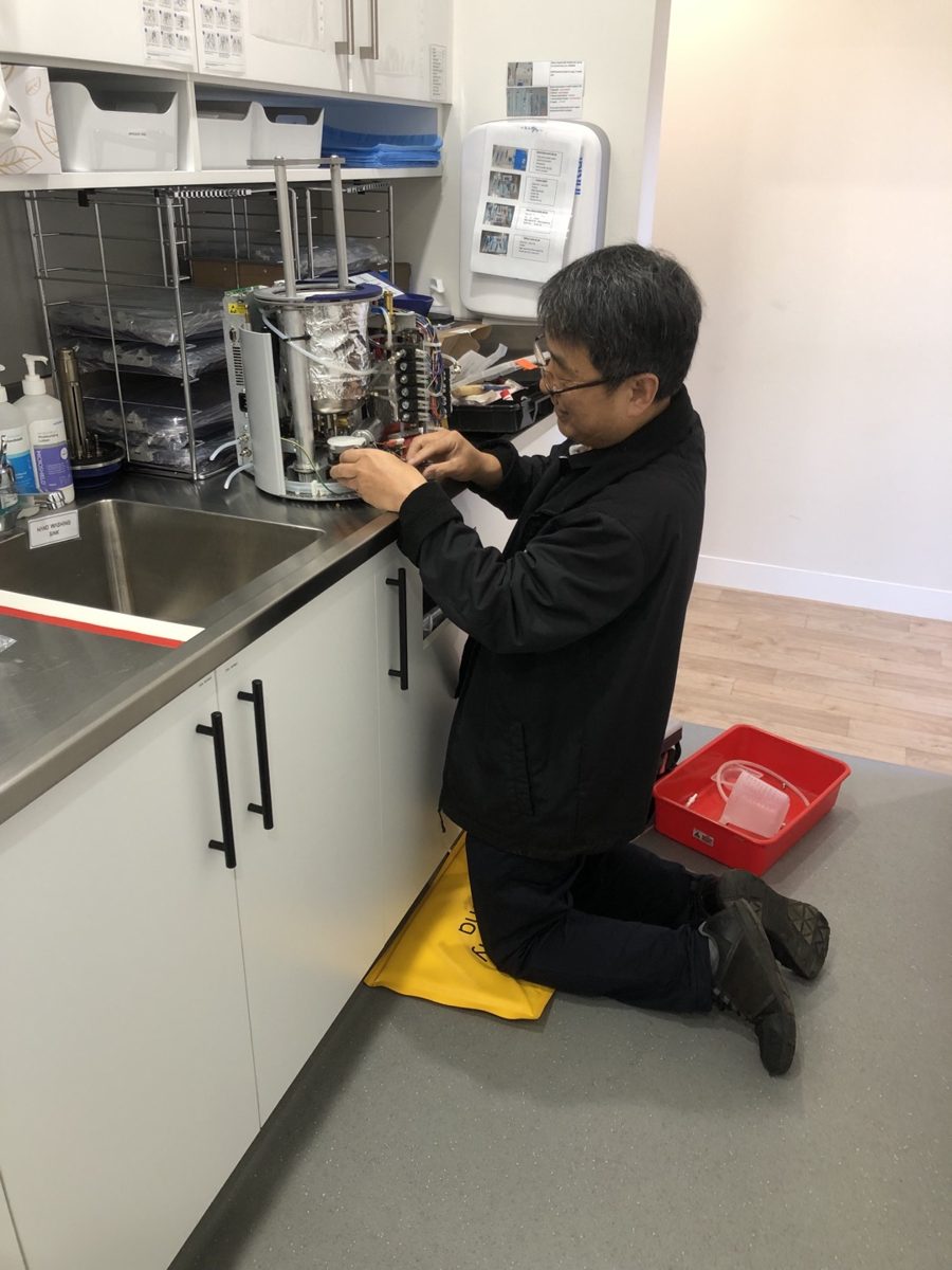 DJ servicing an opened autoclave in a dental clinic sterilisation room